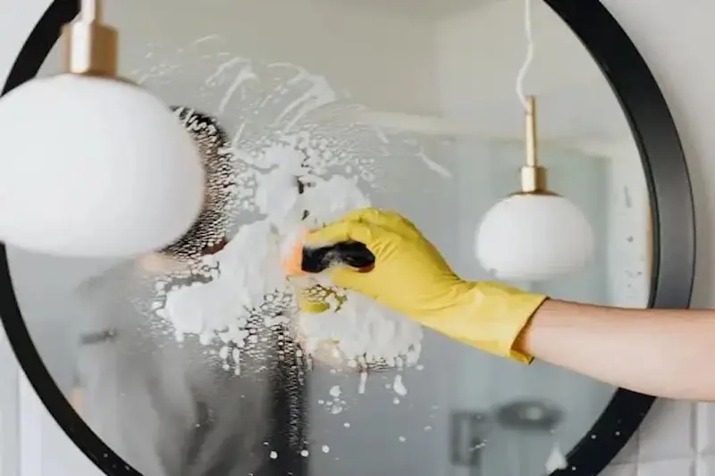 FreshNest cleaning a mirror with a glove